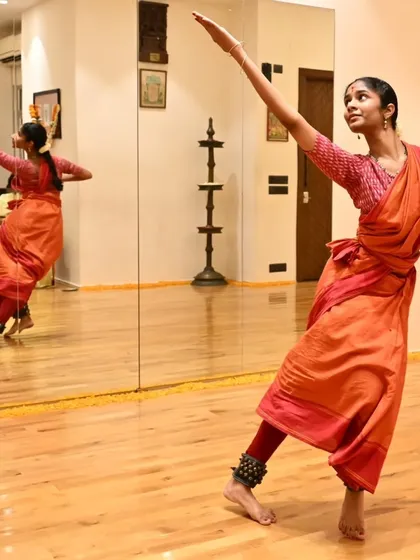 The studio mirror is a dancer's best friend and strictest critic. It helps us perfect our lines, angles, and postures, as seen here with Anvita during her practice.