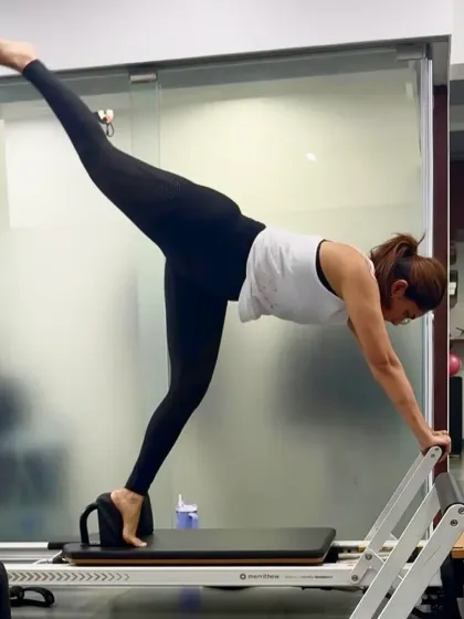 Mrunal Thakur executes a beautiful arabesque on the reformer, a move that requires balance, hip flexibility, and a strong core. This exercise lengthens the spine and strengthens the glutes and hamstrings, creating long, lean lines.