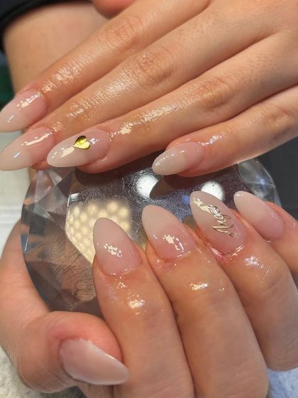 Basic but cute. This simple nude manicure is elevated with a single gold heart charm and a delicate gold leaf accent.