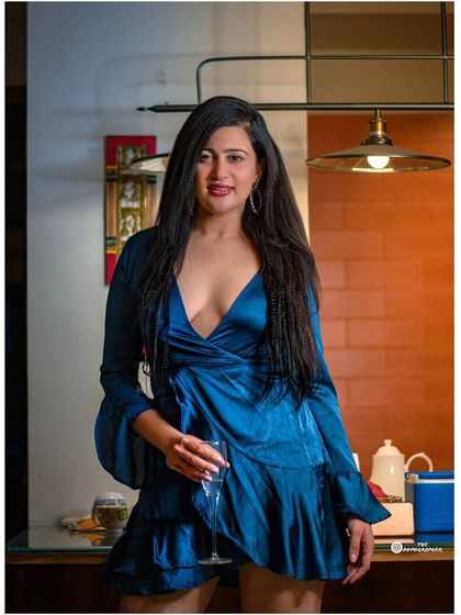 A wider shot from the same set, showing more of the stylish blue dress and the ambient setting.