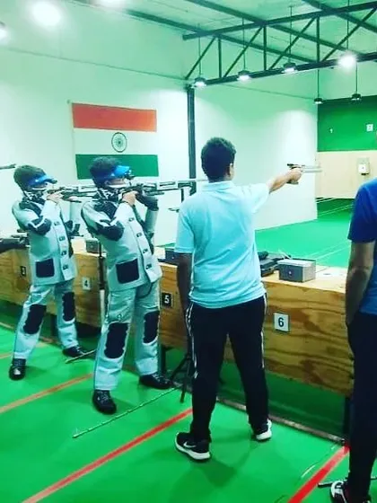 A coach provides guidance during a group training session. We offer hands-on instruction for both air rifle and air pistol disciplines, ensuring every student improves their technique.