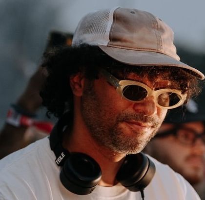 A close-up, candid shot of &ME, capturing his cool, focused demeanor as he curates the soundtrack for the evening.