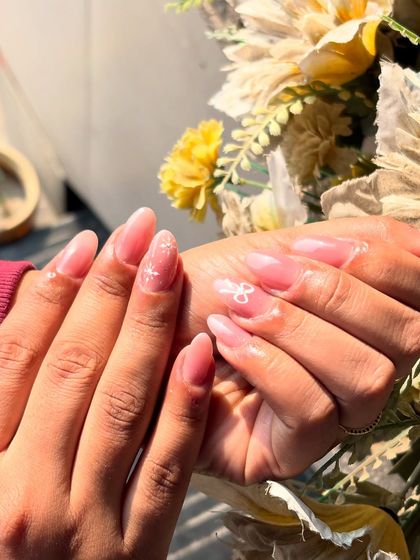 A delicate and pretty design on a sheer pink base, featuring tiny, hand-painted white bows and sparkles.