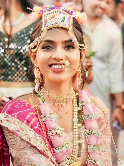 The joy of the wedding rituals. This close-up shows her radiant smile and the traditional 'Mor' worn by Gujarati brides.
