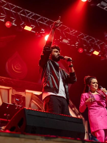 Mithoon on stage with another vocalist, highlighting the collaborative nature of the show.