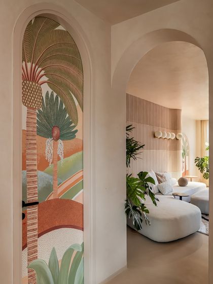 This arched passageway features a hand-painted mural that cleverly conceals a powder room door. It's a perfect example of how we integrate function and art to create a seamless and surprising design.