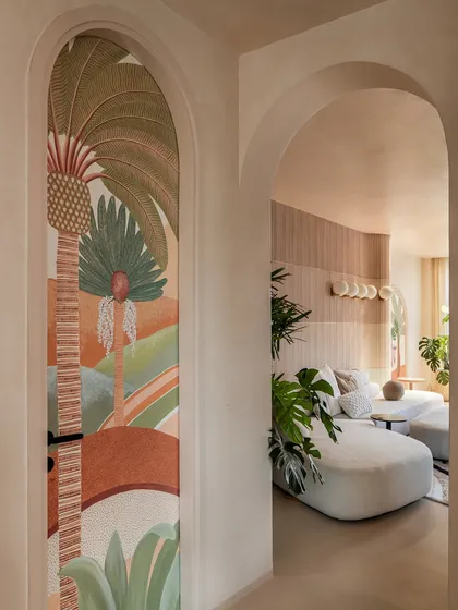 This arched passageway features a hand-painted mural that cleverly conceals a powder room door. It's a perfect example of how we integrate function and art to create a seamless and surprising design.