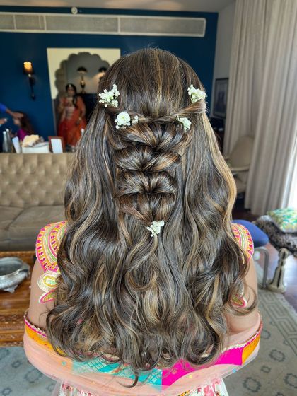 The delicate white flowers add a touch of freshness and elegance to this detailed hairstyle.