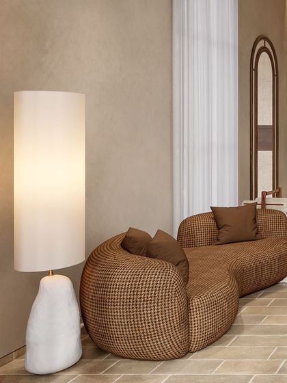 A detail shot of the lounge area in the Siroi Lily bedroom. The houndstooth-patterned chaise and sculptural floor lamp add layers of texture and form to the serene, earth-toned space.