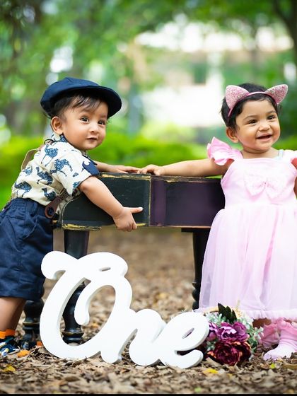 A boy and a girl celebrating their first birthday together with a piano prop in the park. A perfect theme for a duo.