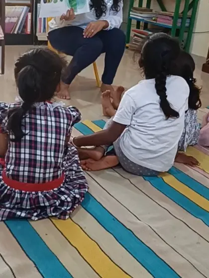The children are seen from behind, all facing the storyteller, highlighting their collective focus.