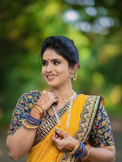 The combination of a Kalamkari blouse with a traditional nauvari is a beautiful fusion. The makeup is kept soft to balance the look.