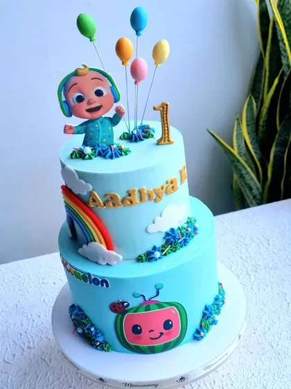 A bright and happy two-tier Cocomelon cake. This design includes a 2D fondant watermelon and a 3D sculpted JJ topper, showing how to combine different techniques for a playful effect.