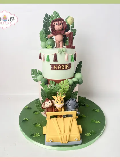 Welcome to the jungle! This two-tiered safari cake is an adventure in itself, featuring a jeep full of handcrafted fondant animals like a lion, monkey, and giraffe. It's a perfect centerpiece for a wild and fun first birthday party.