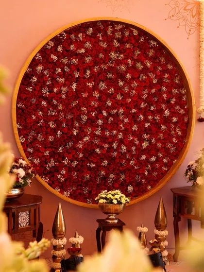 A circular backdrop filled with a dense arrangement of red and white rose petals, creating a powerful and romantic focal point for the Shri Yantra themed wedding.