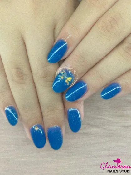 Simple, shimmery, and sweet. This manicure features a beautiful shimmering blue polish, accented with clean white lines and a tiny gold bow.