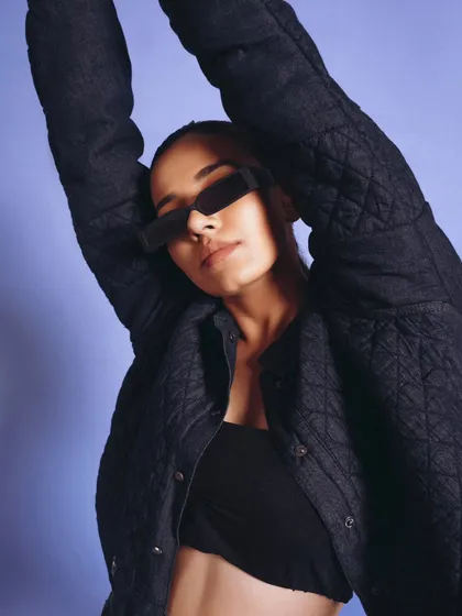 A cool, relaxed portrait for a denim jacket. The model's pose and sunglasses give off an effortless, contemporary vibe.
