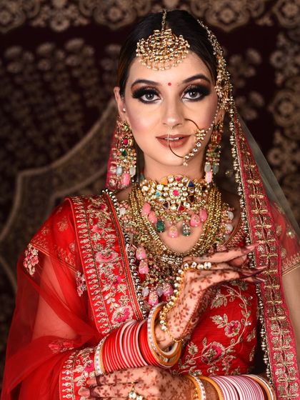 This bride chose a vibrant red lehenga and complemented it with a stunning, multi-layered Polki necklace with colorful pastel drops. A perfect example of creating a custom look through our rental service.