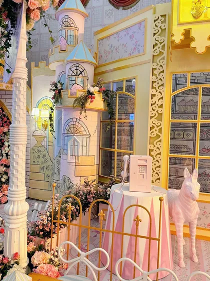 A hand-painted castle turret and striped fence add to the storybook village atmosphere.
