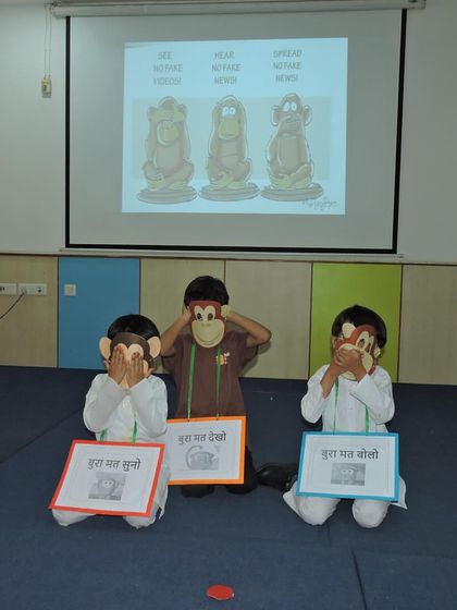Students dressed as Gandhi's three monkeys enact the principle of "see no evil, hear no evil, speak no evil" during the Gandhi Jayanti assembly.