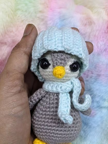 Holding the little penguin to show its size and details.