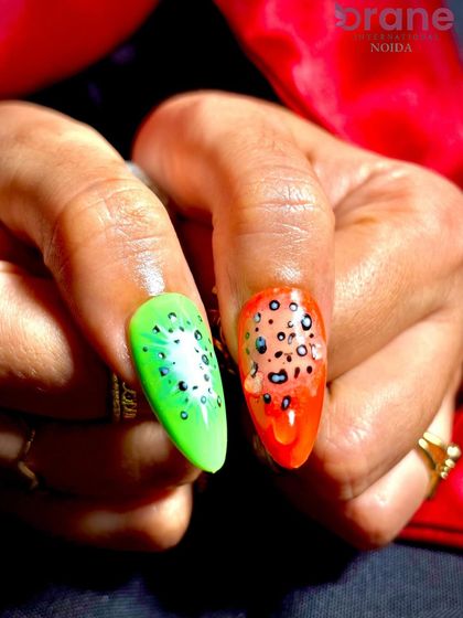 A detailed shot of kiwi and papaya-inspired nail art, showcasing creative use of color and texture.