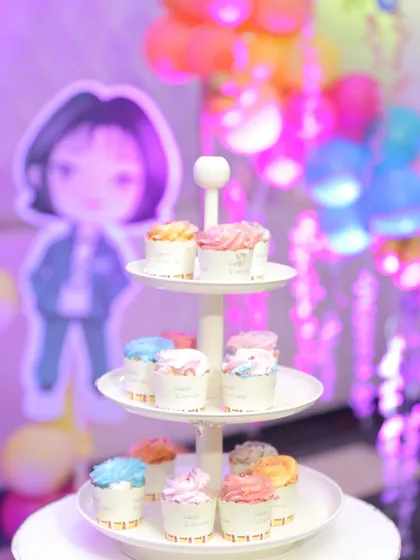 Even the desserts can match the theme. Here is a cupcake stand at the 'Squid Fiesta' party, with a character cutout visible in the background, showing how every detail is considered.