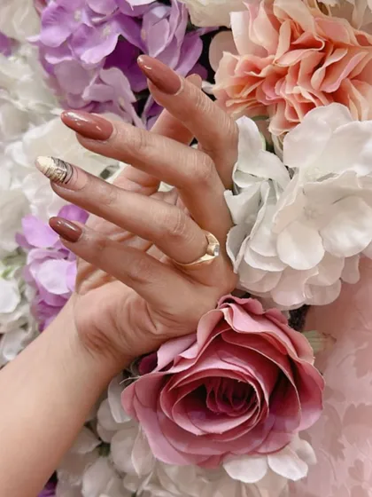 A simple yet chic design with a solid dusty rose color and a single accent nail with a gold and white abstract design.