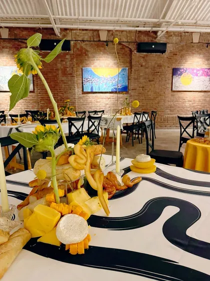 A wider view of the dining setup, showing how the artistic tablescapes fit within the gallery space.