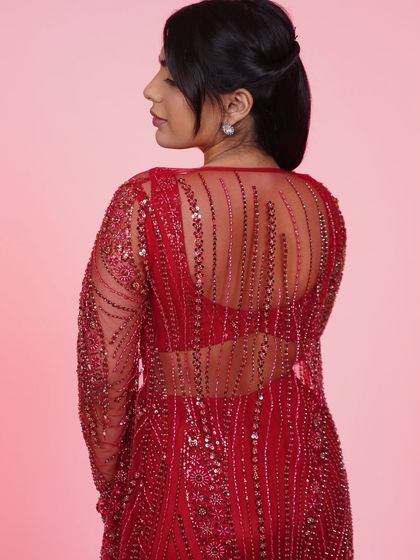 A back view of the red three-piece set, showing the sheer, embroidered jacket that adds a touch of elegance and drama.