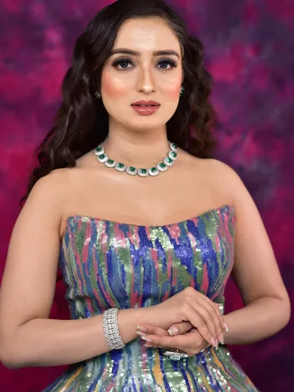 A client looking chic and modern in a multi-colored sequin gown, paired with our elegant emerald and diamond necklace. Perfect for a cocktail night.