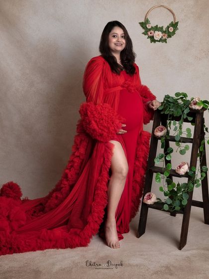 A pop of red against a neutral background. This portrait uses a simple ladder prop with flowers to add a rustic touch to a glamorous look.