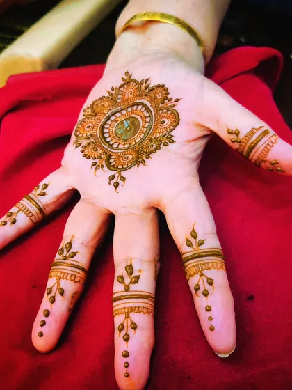 A simple mandala on the back of the hand with delicate finger details. This is a classic, go-to design that always looks beautiful.