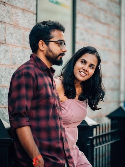 A playful glance from the woman as her partner looks on, captured during a casual street-style photoshoot.