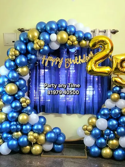 A 25th birthday celebration with a blue, gold, and white balloon arch. The foil number balloons are a great way to highlight the milestone age.