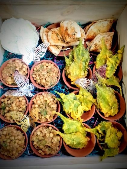 A chaat platter box featuring crispy palak patta chaat and chole, decorated with delicate butterfly cutouts for a touch of whimsy.