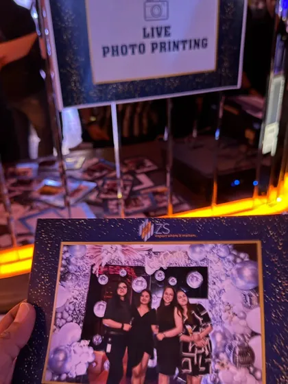 A live photo printing booth in action. This is a fantastic party favor, allowing guests to take home a branded, printed memory from the event instantly.