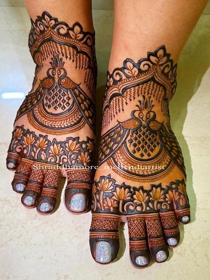 A detailed peacock and lotus design for the feet. The intricate feathers and petals create a rich, full look that is perfect for any bride.