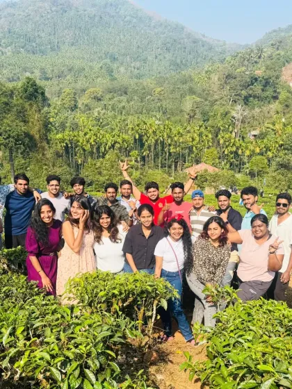 A group enjoying the fresh air and beautiful scenery of a tea garden in Wayanad. It's a refreshing break from city life.
