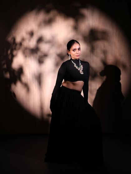 A dramatic, full-length shot for Qis by Ashmeet, using creative lighting to cast an artistic shadow and create a high-fashion look.