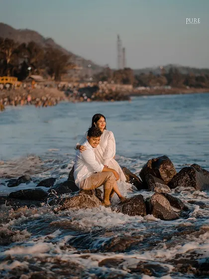 Komal and Ajit sit together on a rock as the tide comes in around them. This shot beautifully integrates the couple into the natural landscape of the beach.