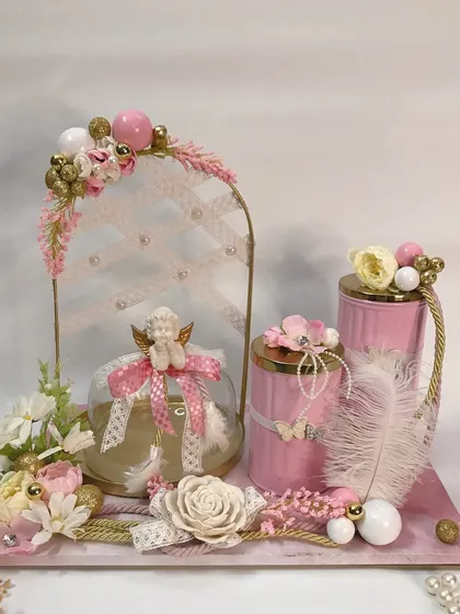 Creating memories with this handcrafted angel-themed hamper in soft pink. The delicate details like the angel figurine, feathers, and lace make this a truly heavenly gift.