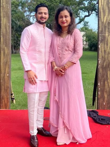 A beautiful example of color coordination. The groom wears a pink kurta with a matching short jacket detailed with katdana work, perfectly complementing his mother's pink outfit.