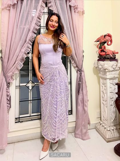 A full-length photo of our client wearing the lilac satin corset and beaded drape skirt, a perfect look for a cocktail party.