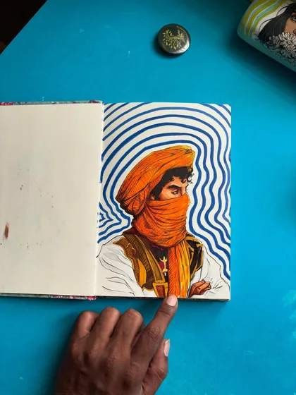 Here I am pointing out a detail in the finished artwork. Every part of this hand-drawn illustration, from the folds of the fabric to the hypnotic background, is done by hand.