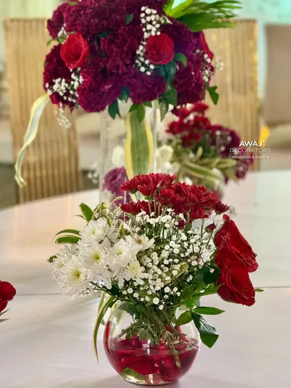A close-up of the simple yet beautiful centerpiece, with red and white flowers in clear glass vases.
