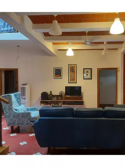 A living room with a jack arch roof and patterned Athangudi tile flooring, furnished with comfortable, contemporary pieces.