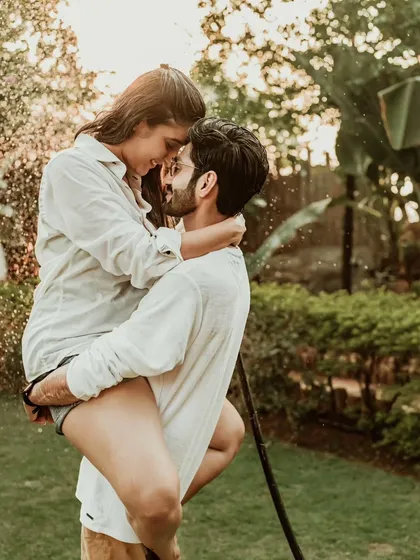 Pure, uninhibited joy as a couple plays with a water hose during a golden hour pre-wedding shoot. We focus on capturing these real, candid moments of laughter that truly define your relationship.
