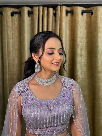 The front view, showing the soft, face-framing tendrils and the beautiful lavender-toned makeup that complements the outfit.