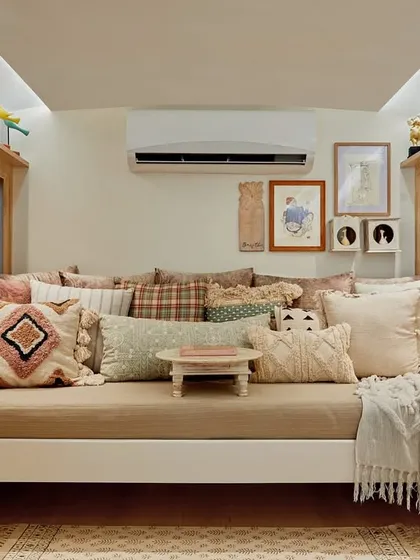 In a space of less than 80 sq. ft., creating a true sanctuary to unwind is my primary goal. This cozy daybed, which converts into a full bed for naps, is the heart of the lounge area. I layered multiple textures and prints with the cushions to add warmth and character, while an upcycled bajot serves as a versatile coffee table, making this nook both comfortable and practical.